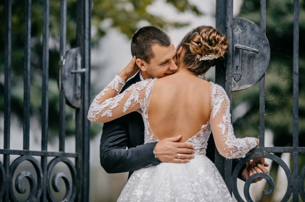Novios de boda abrazándose en la puerta
