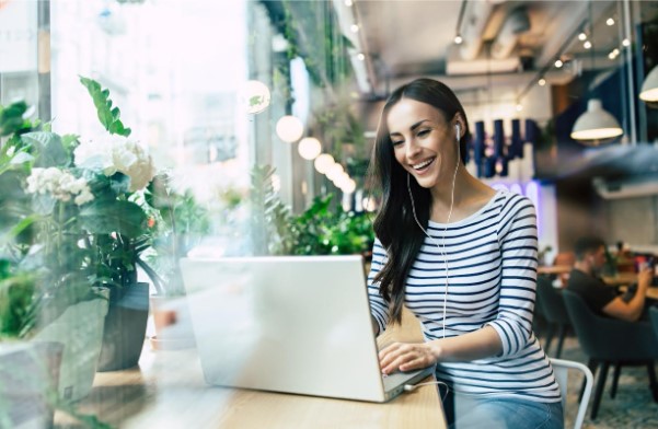 Mujer trabajando en cafeteria con portatil
