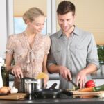 Pareja cocinando pasta con verduras