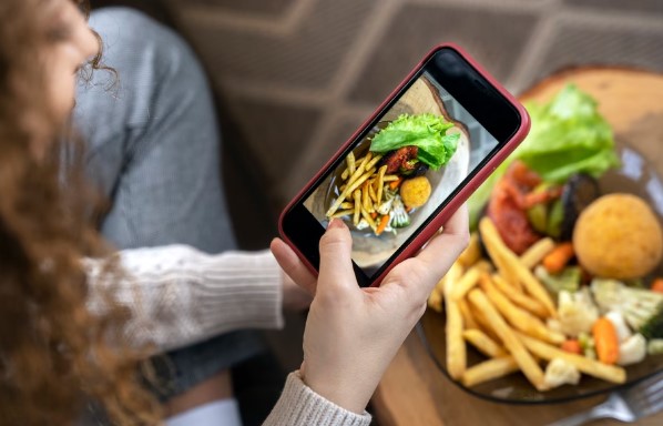 Mujer haciendo foto de plato de comida