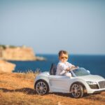 Niño conduciendo audi electrico frente al mar